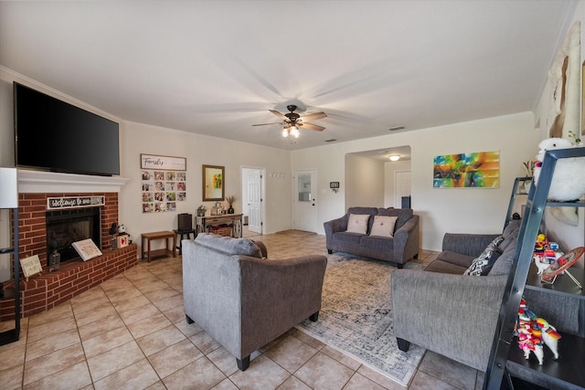 living room featuring ceiling fan, a brick fireplace, visible vents, and light tile patterned floors