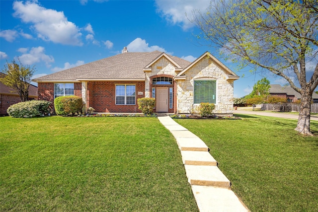 1919 Water Fall Way, Wylie, TX 75098 - view of front of home with a chimney, brick siding, stone siding, roof with shingles, and a front yard