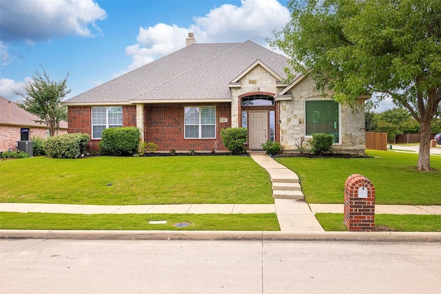 1919 Water Fall Way, Wylie, TX 75098 - french country home featuring a front yard, stone siding, roof with shingles, a chimney, and brick siding