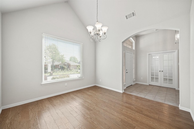 1919 Water Fall Way, Wylie, TX 75098 - empty room featuring arched walkways, wood finished floors, a chandelier, high vaulted ceiling, and baseboards
