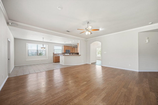 1919 Water Fall Way, Wylie, TX 75098 - unfurnished living room with arched walkways, a ceiling fan, light wood-style floors, ornamental molding, and baseboards