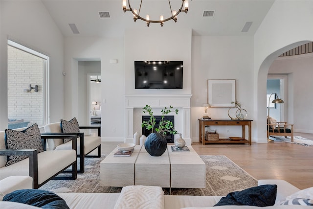 3101 Twin Eagles Dr, Celina, TX 75009 - living room with visible vents, arched walkways, a notable chandelier, and wood finished floors