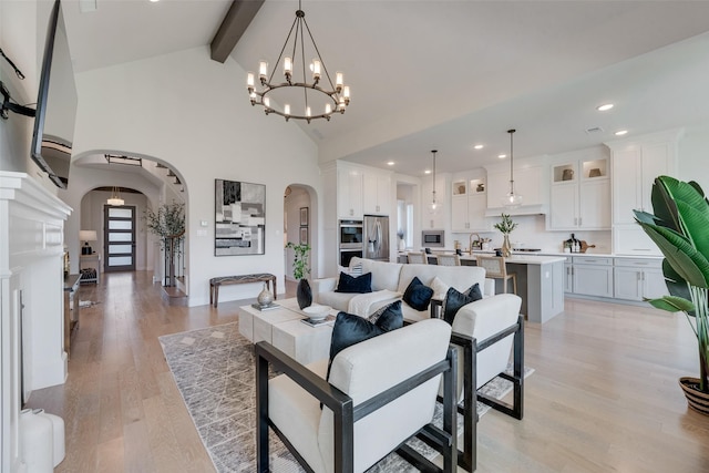 3101 Twin Eagles Dr, Celina, TX 75009 - living area with a chandelier, light wood-style floors, beamed ceiling, high vaulted ceiling, and arched walkways