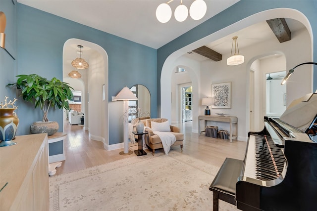 3101 Twin Eagles Dr, Celina, TX 75009 - living area featuring arched walkways, wood finished floors, beam ceiling, and a wealth of natural light