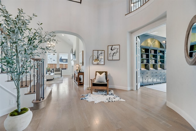 3101 Twin Eagles Dr, Celina, TX 75009 - entryway featuring arched walkways, a high ceiling, baseboards, and wood finished floors