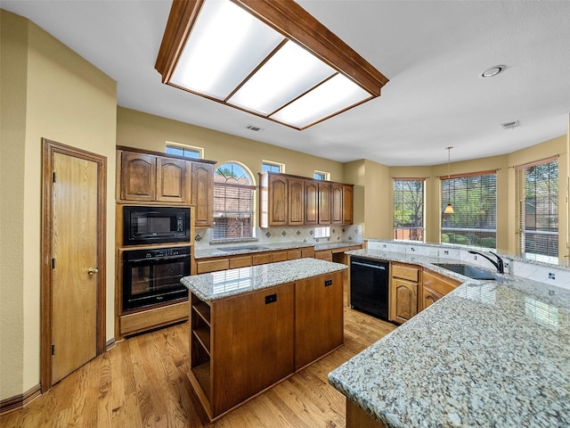 1213 Hills Creek Dr, Mckinney, TX 75072 - kitchen with black appliances, a sink, a center island, backsplash, and light wood finished floors