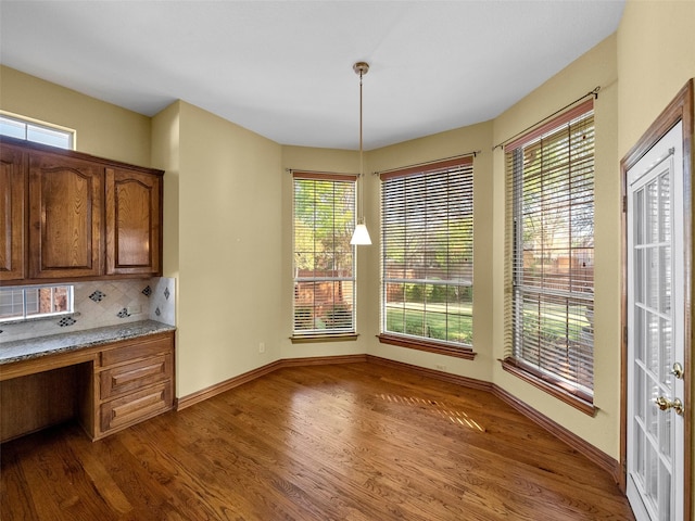 1213 Hills Creek Dr, Mckinney, TX 75072 - unfurnished dining area featuring wood finished floors, healthy amount of natural light, and baseboards