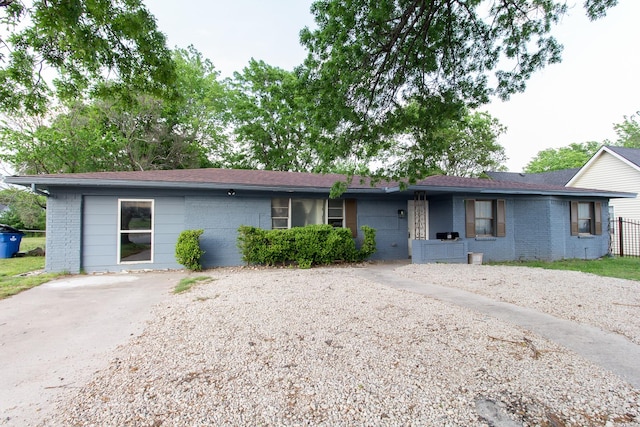 ranch-style home with roof with shingles and brick siding