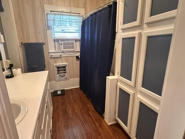 full bathroom with a shower with shower curtain, heating unit, cooling unit, vanity, and wood finished floors