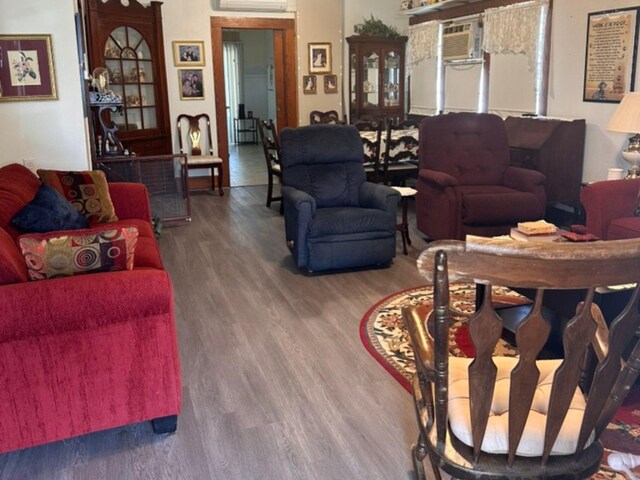 living room featuring a wall mounted AC and wood finished floors