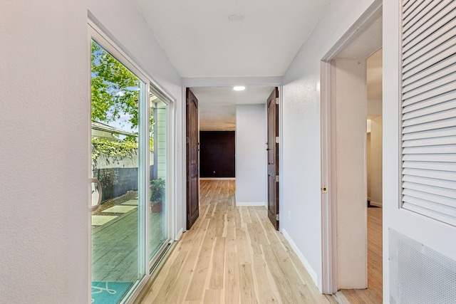 hall featuring baseboards, light wood-type flooring, and recessed lighting
