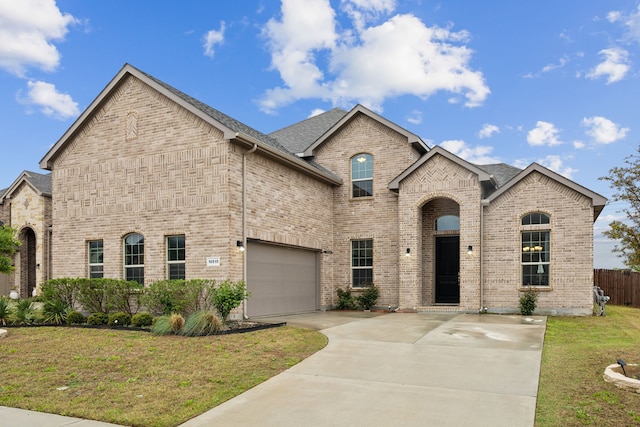 10515 Forest Glen Ln, Grand Prairie, TX 76065 - french country style house featuring brick siding, concrete driveway, a garage, and roof with shingles