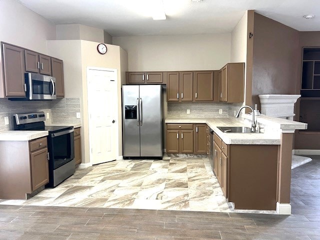 518 Lonestar Park Ln, Ponder, TX 76259 - kitchen featuring stainless steel appliances, a peninsula, tasteful backsplash, and light countertops