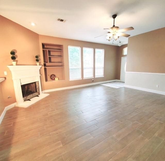 518 Lonestar Park Ln, Ponder, TX 76259 - unfurnished living room featuring a ceiling fan, a fireplace, wood finished floors, built in shelves, and recessed lighting