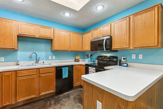 kitchen featuring a peninsula, a sink, a textured ceiling, a skylight, and black appliances