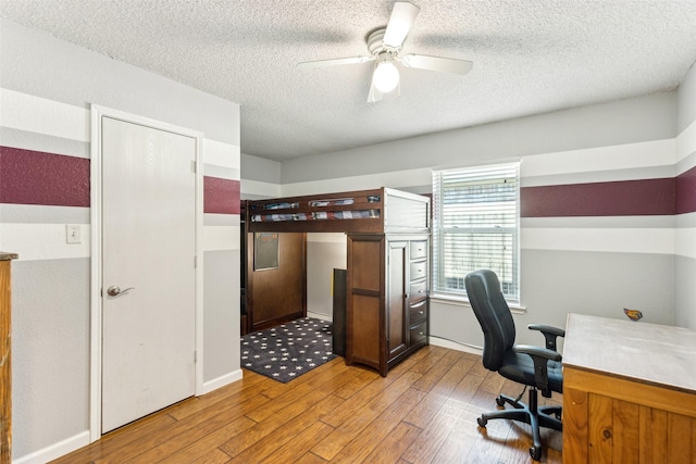 office space with a ceiling fan, a textured ceiling, and light wood-style flooring