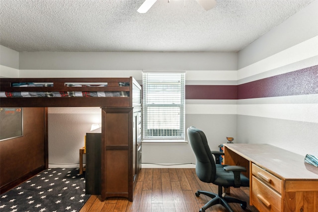 office area featuring baseboards, a textured ceiling, ceiling fan, and wood-type flooring