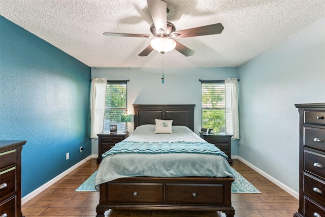 bedroom featuring a ceiling fan, baseboards, a textured ceiling, and dark wood finished floors