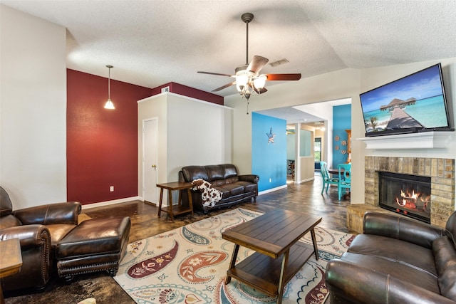 living area featuring a fireplace, baseboards, a textured ceiling, and ceiling fan