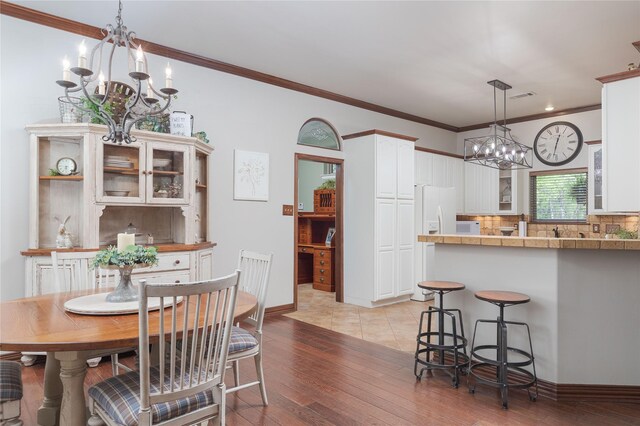 10248 N Poetry Ln, Terrell, TX 75160 - dining area featuring baseboards, light wood-type flooring, an inviting chandelier, ornamental molding, and visible vents