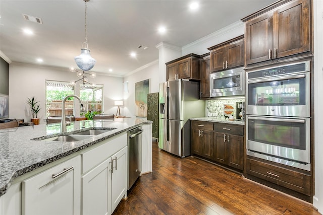 kitchen with light stone countertops, dark brown cabinets, visible vents, a sink, and stainless steel appliances
