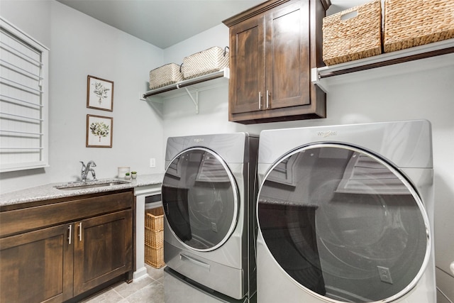 laundry room with light tile patterned flooring, a sink, cabinet space, and washer and clothes dryer