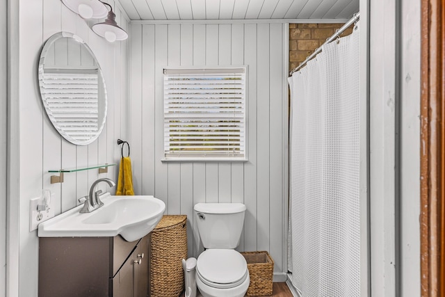 full bathroom with toilet, vanity, a shower with shower curtain, and wooden walls