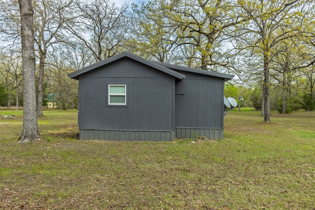 view of home's exterior featuring an outbuilding and a lawn