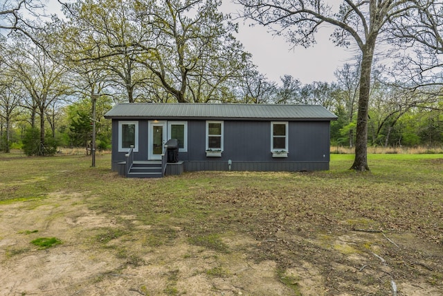 manufactured / mobile home with a front yard and metal roof