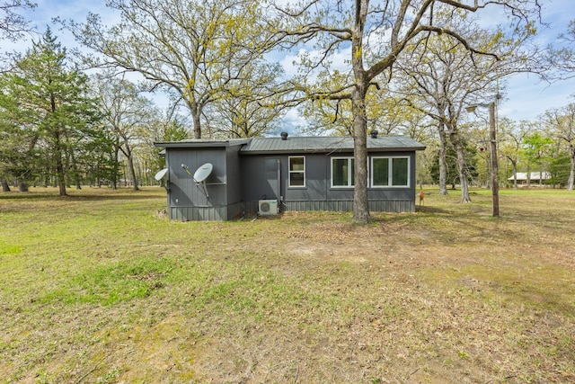 back of property featuring a yard and ac unit