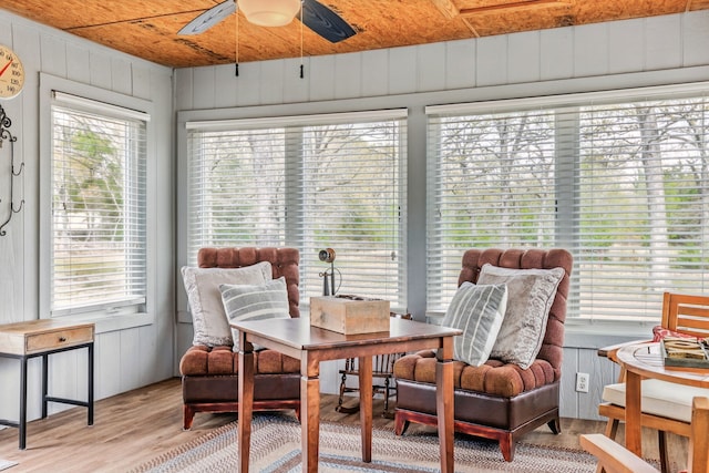 sunroom with wooden walls and wood finished floors