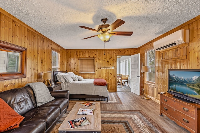 bedroom featuring wooden walls, multiple windows, and an AC wall unit