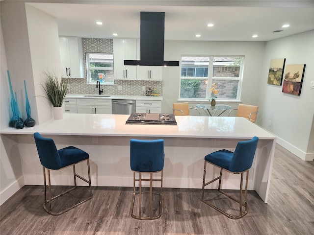 5515 Enchanted Ln, Dallas, TX 75227 - kitchen with island exhaust hood, a sink, wood finished floors, white cabinetry, and baseboards