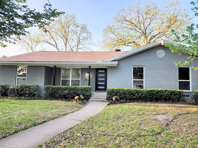 5515 Enchanted Ln, Dallas, TX 75227 - mid-century modern home featuring a front yard, brick siding, covered porch, and a chimney