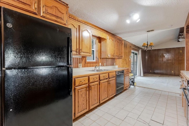kitchen with visible vents, vaulted ceiling, black appliances, wood walls, and light countertops