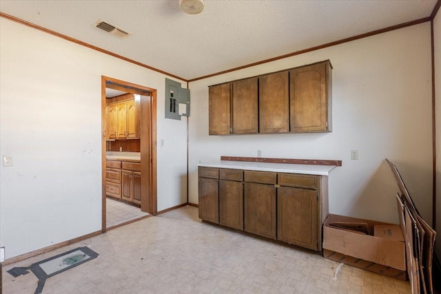 kitchen with ornamental molding, visible vents, light floors, and electric panel