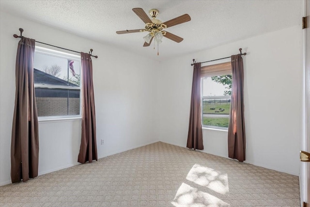 carpeted empty room with a ceiling fan and a textured ceiling