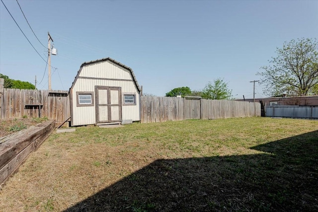 view of yard with a shed, a fenced backyard, and an outbuilding