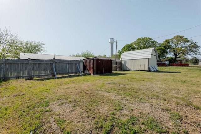 view of yard featuring a storage shed, an outdoor structure, and fence