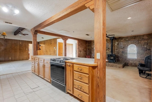 kitchen featuring wooden walls, open floor plan, a textured ceiling, and range with electric stovetop