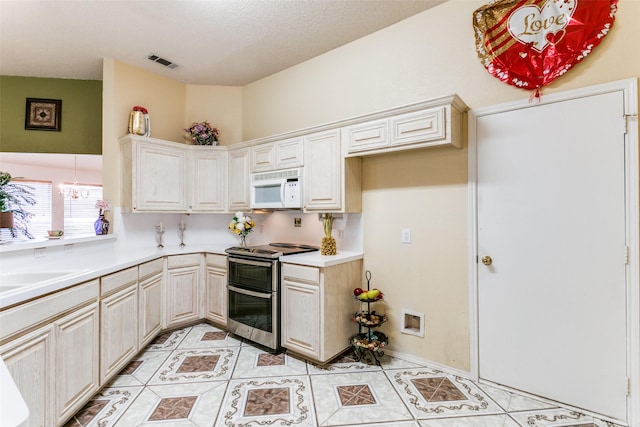 3012 Silent Creek Trl, Fort Worth, TX 76053 - kitchen featuring white microwave, range with two ovens, light tile patterned floors, and light countertops
