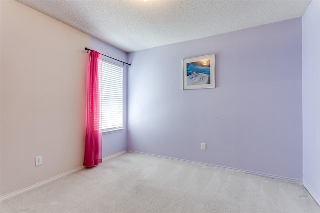 empty room with baseboards, carpet flooring, and a textured ceiling