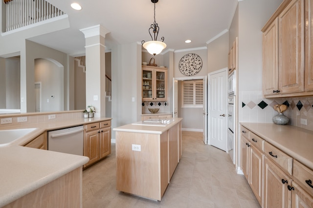kitchen with a center island, backsplash, white appliances, light brown cabinets, and light countertops