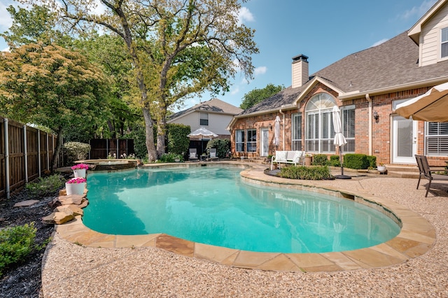 outdoor pool with a fenced backyard and a patio