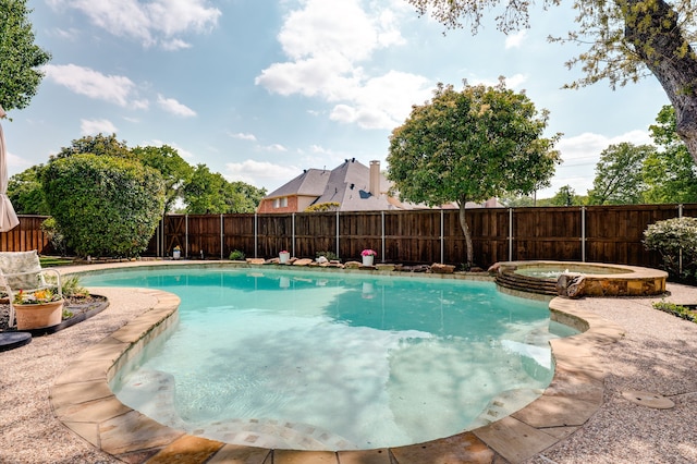 view of swimming pool featuring a fenced backyard and a pool with connected hot tub