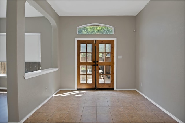 9409 Stonewood Dr, Mckinney, TX 75072 - entrance foyer featuring french doors, arched walkways, tile patterned flooring, and baseboards