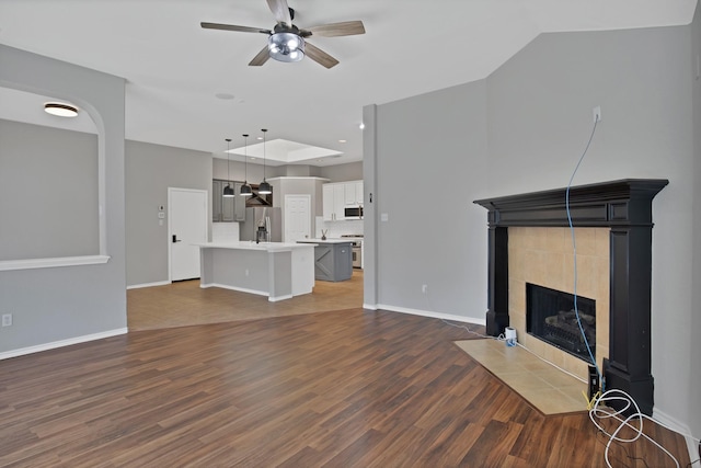 9409 Stonewood Dr, Mckinney, TX 75072 - unfurnished living room with ceiling fan, wood finished floors, a fireplace, and baseboards