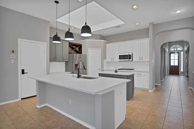 9409 Stonewood Dr, Mckinney, TX 75072 - kitchen featuring white microwave, an island with sink, a sink, light tile patterned flooring, and recessed lighting