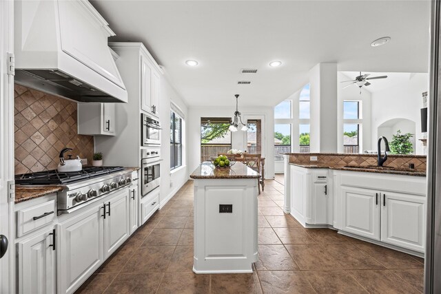 4504 Oxbow Dr, Mckinney, TX 75072 - kitchen featuring custom range hood, a sink, appliances with stainless steel finishes, white cabinetry, and dark stone countertops