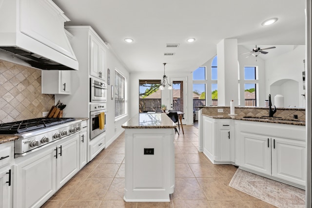 4504 Oxbow Dr, Mckinney, TX 75072 - kitchen with extractor fan, stainless steel gas cooktop, a sink, a ceiling fan, and a kitchen island